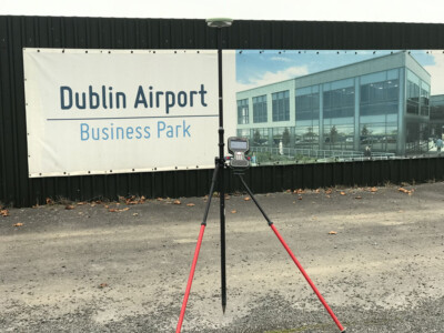 Survey instrument on a tripod at the Dublin Airport Business Park hoarding