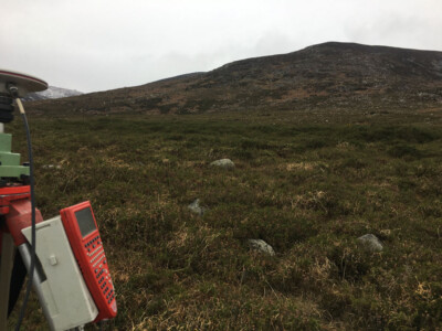 Survey instrument in the foreground of heather moorland and hillside