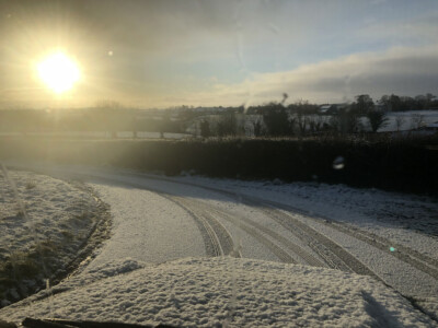 Frost covered field at sunrise seen over the bonnet of a survey vehicle