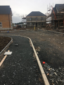 New housing under construction with scaffolding and a newly kerbed road